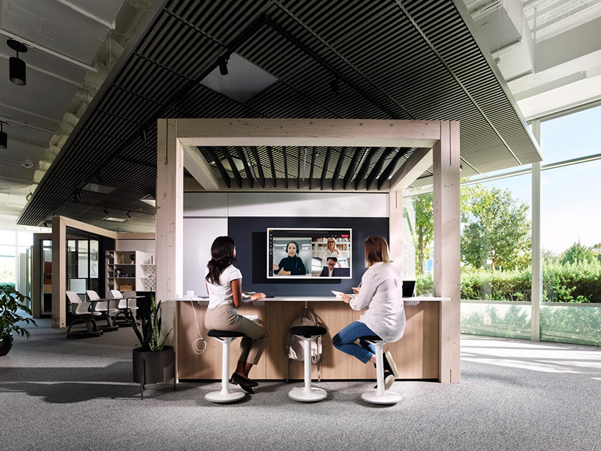 Onsite office workers collaborating with remote co-workers in a modern and stylish conference room.